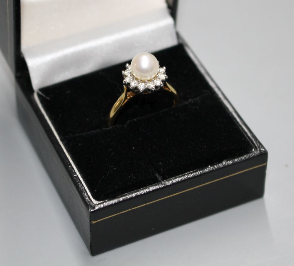 A modern 18ct gold, cultured pearl and diamond cluster set flower head ring, gross 4.4. grams.